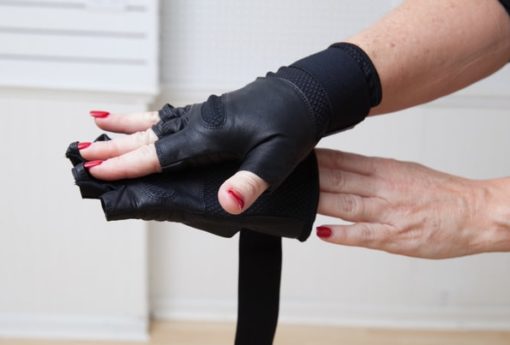 woman putting on WAGs Fusion fitness gloves